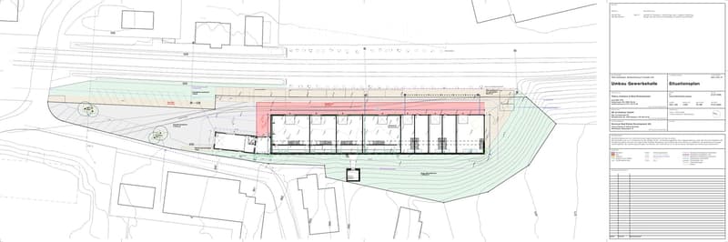 Site plan showing a commercial building with multiple sections, parking areas, and surrounding terrain contours.