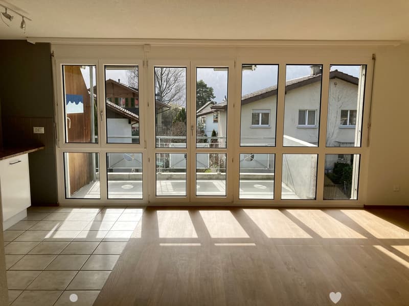 Empty room with large windows and wooden flooring, natural light streaming in, no furniture or equipment present.
