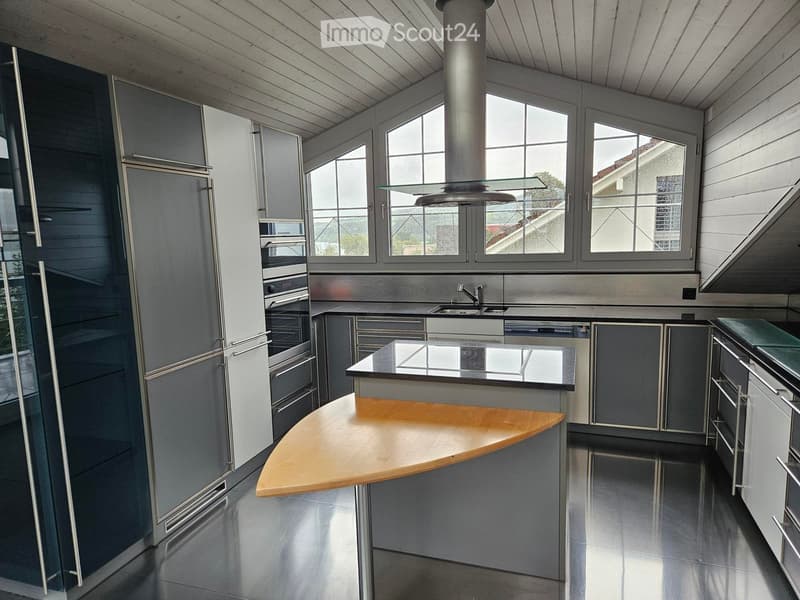 modern kitchen with island, stainless steel appliances, wooden countertops, large windows, metal flooring
