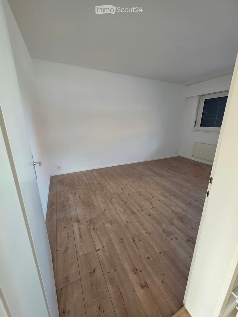 Empty room with wooden flooring, white walls, and a window with blinds. No furniture or equipment is present.