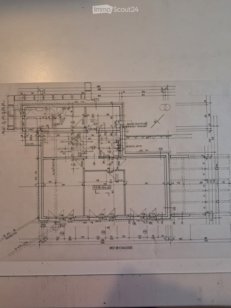 Ground floor plan of a house with labeled rooms, dimensions, and drainage details.