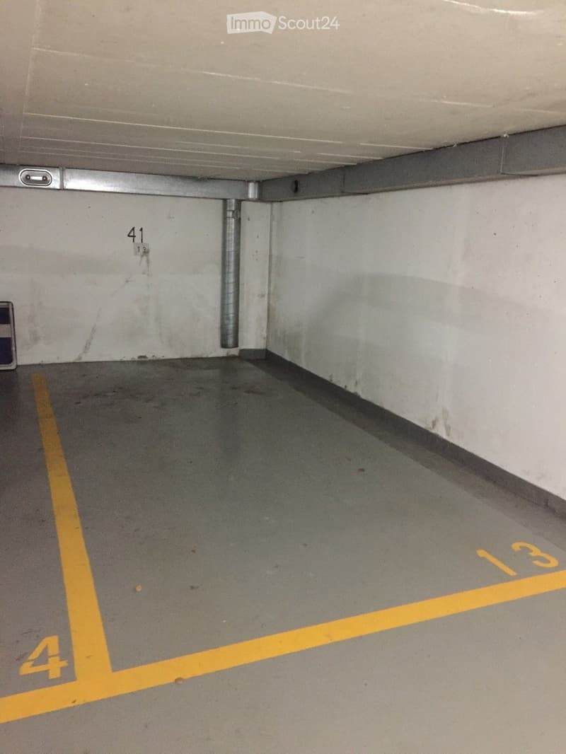 Empty underground parking space with marked parking spots and numbered sections.