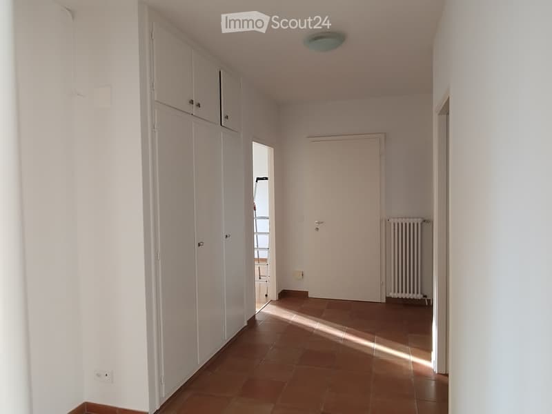Empty room with white walls, a skylight window, a radiator, and a built-in cabinet. No furniture or personal items are present.