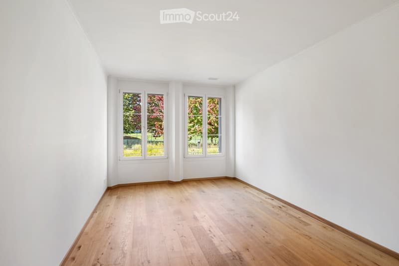 Completely empty room with bare white walls and wooden floor. No furniture or equipment.