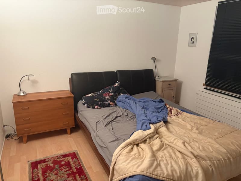 A bedroom with a wooden bed, nightstands, lamps, and a picture frame on the wall.