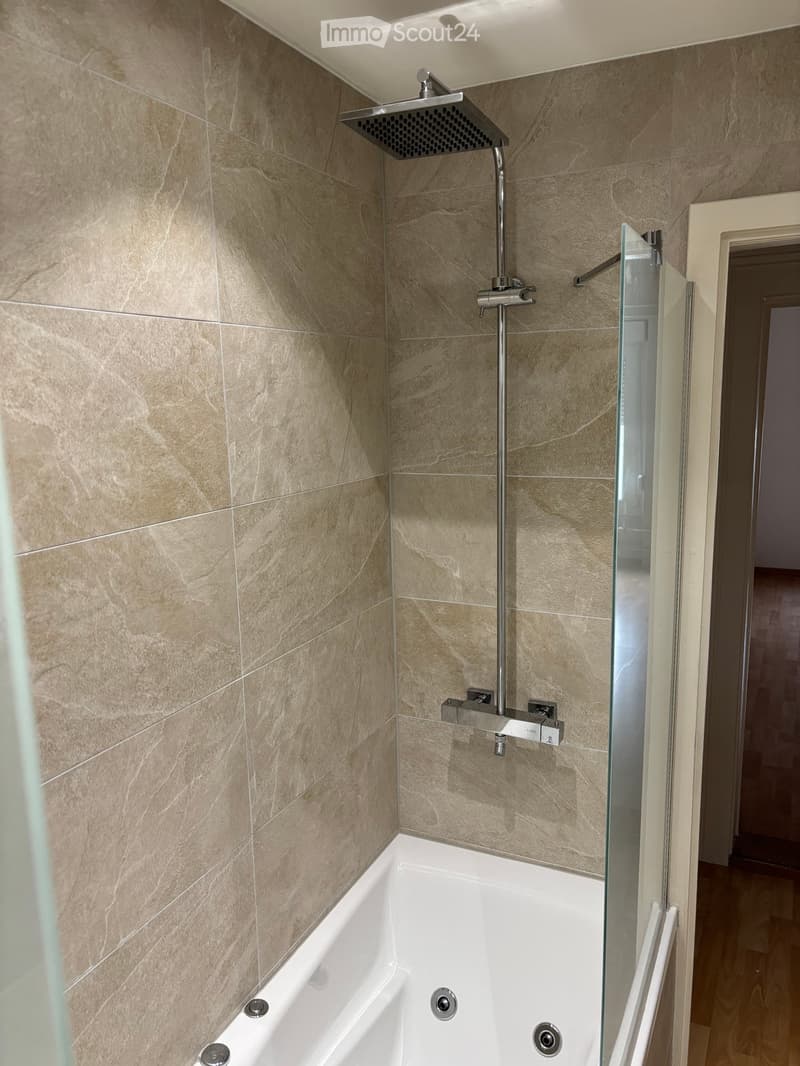 Bathroom with a bathtub, shower, and tiled walls