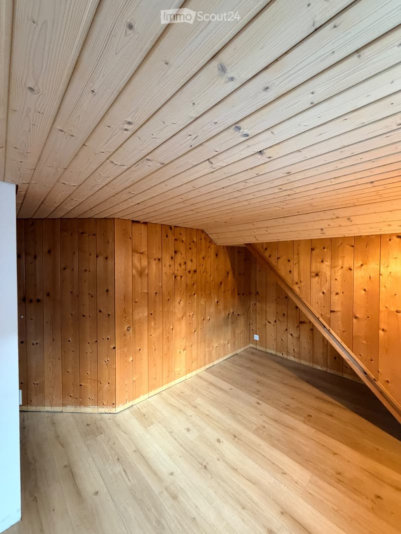 Empty room with wooden walls, wooden ceiling, and wooden floor. No furniture or equipment visible.