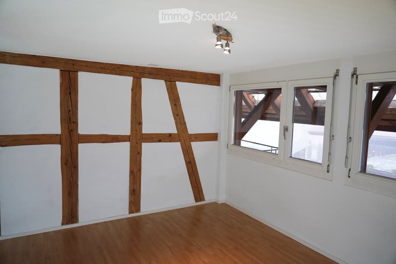 Wooden beams, wooden flooring, white walls, wooden window frames, ceiling spotlights