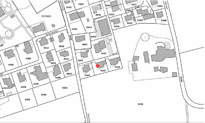 Floor plan of a residential area showing multiple buildings and plots with numbered designations.