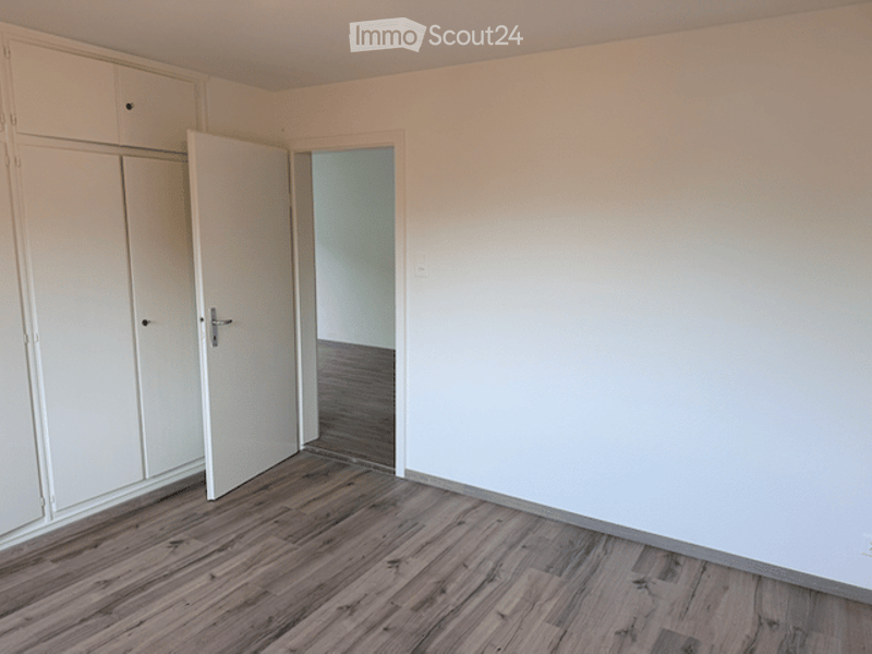 Empty room with wooden flooring, white walls, and built-in white closet units. No furniture or equipment present.