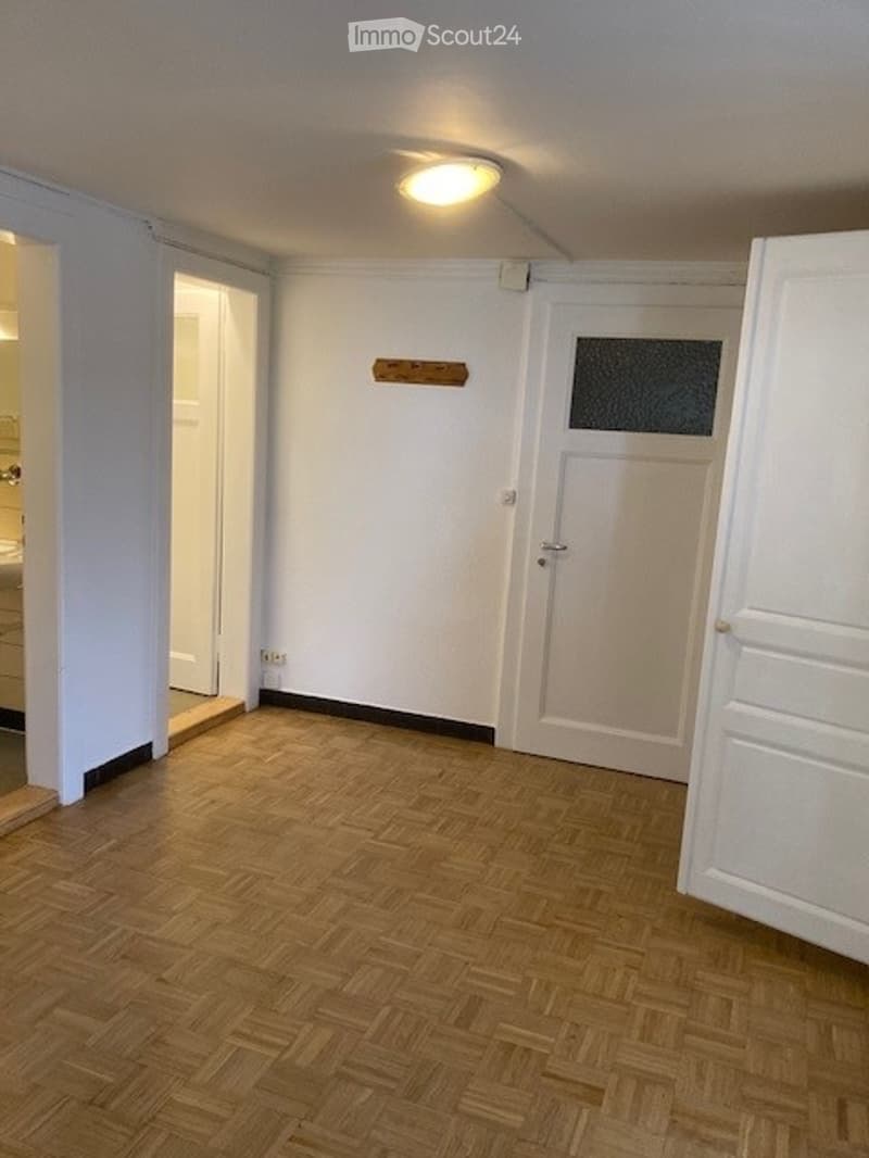 Empty room with wooden flooring, white walls, and a single light fixture on the ceiling. No furniture or equipment is present.