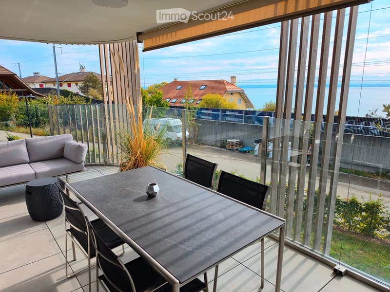 Balcony with a view of the sea, featuring a sofa, a dining table, and chairs.