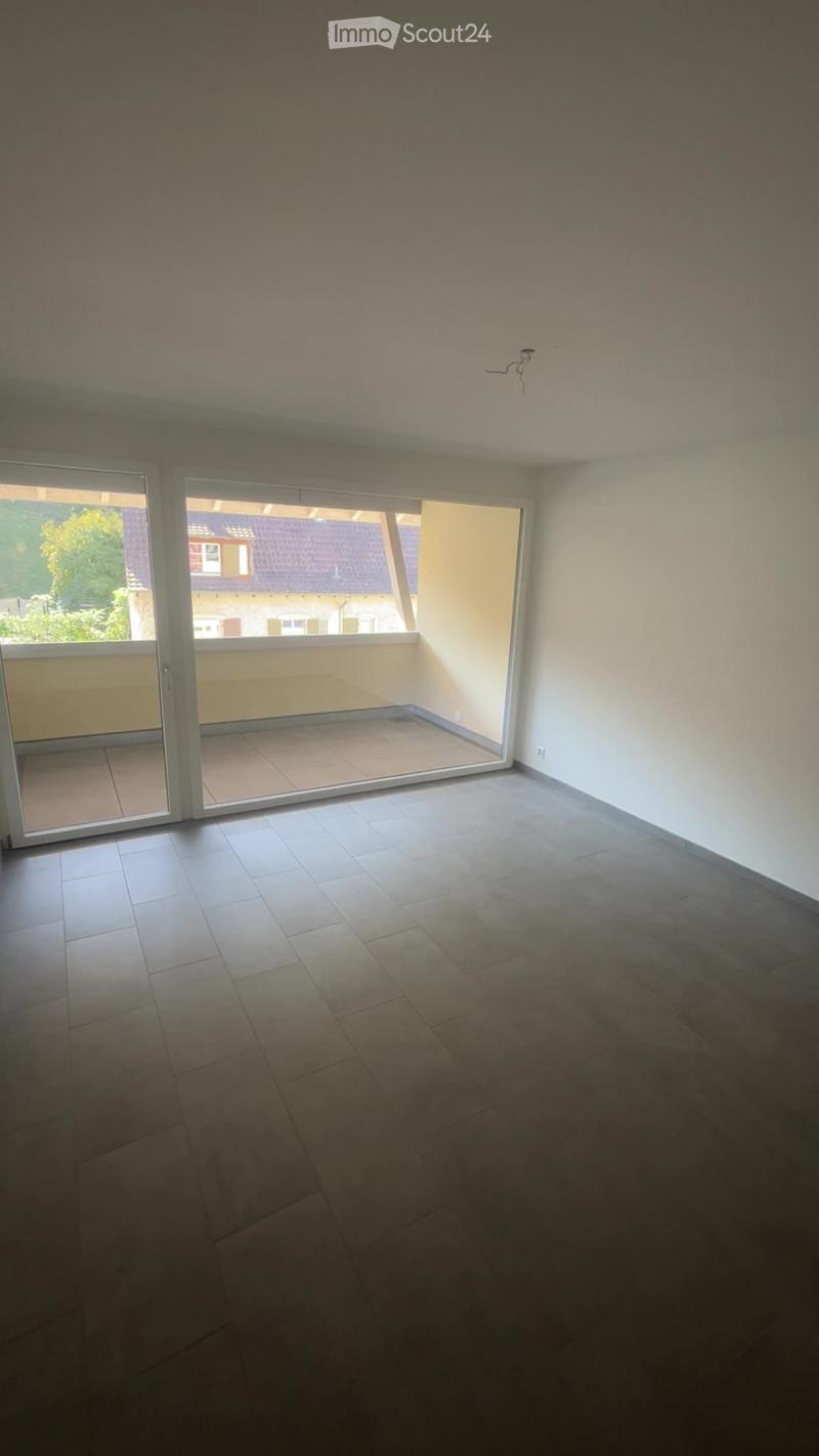 Empty room with tiled floor and large sliding glass doors leading to a balcony area.