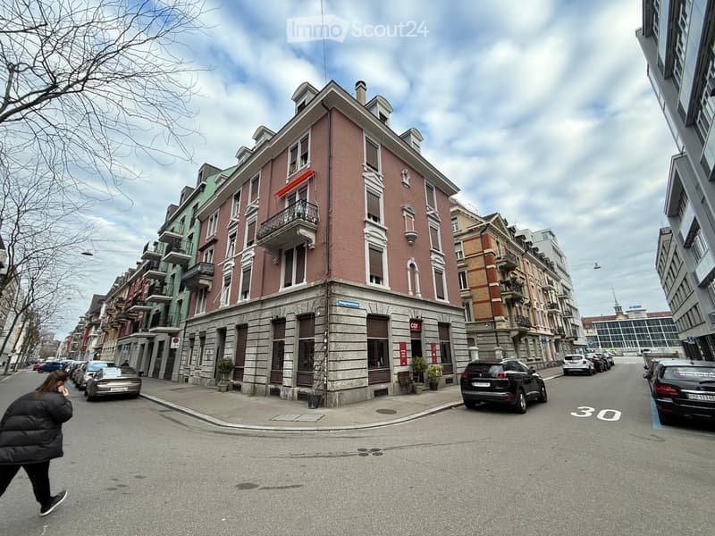 4-storey building with balconies on the upper floors, red walls with white details, multiple balconies