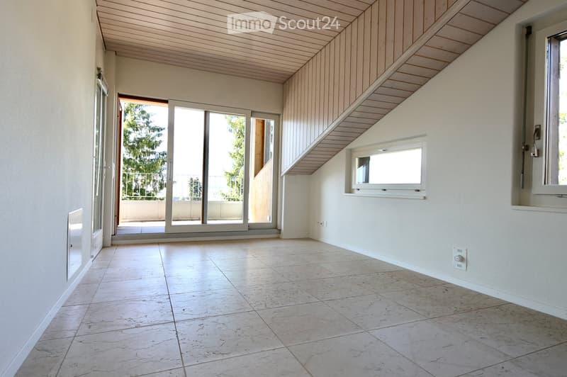Empty room with tiled floor, white walls, and large sliding glass doors leading to a balcony area.