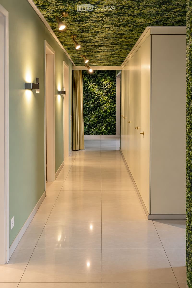Modern hallway with polished tile flooring, green moss wall, recessed lighting, and a large window with curtains at the end.