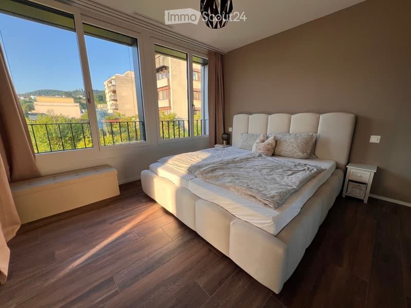 modern bedroom with hardwood floors, a large bed, balcony, and panoramic view