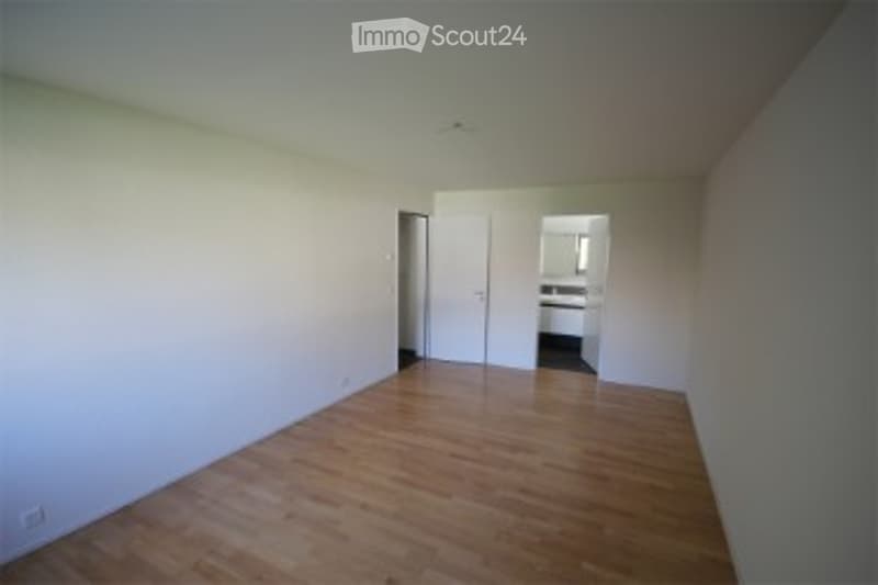 Completely empty room with light wooden flooring and white walls. No furniture or equipment.
