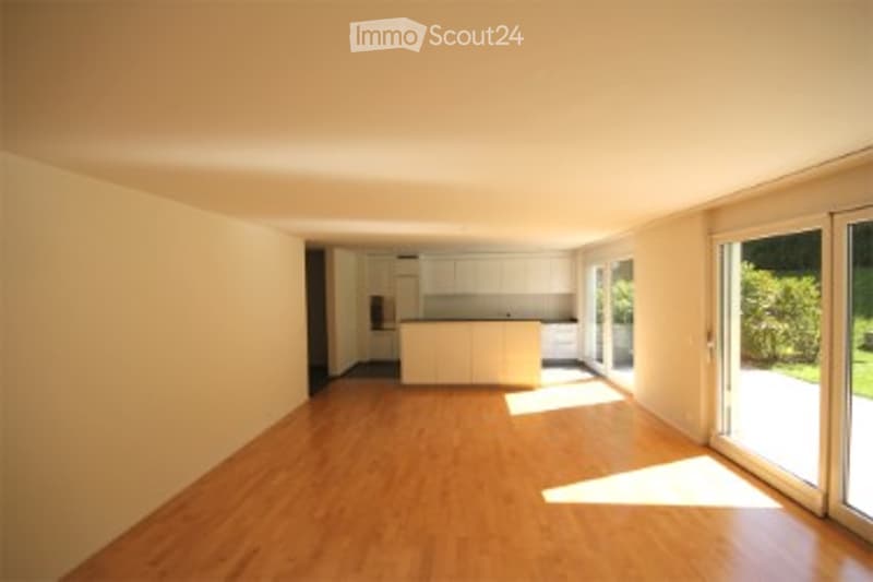 Empty room with wooden flooring, white walls, and large windows. No furniture or equipment present.