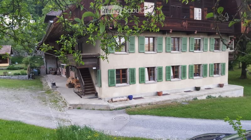 2 story house, brown wood exterior, green shutters, gravel driveway, exterior staircase