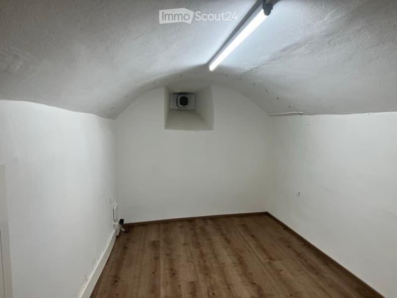 empty room, white walls, brown hardwood floor, recessed ceiling light