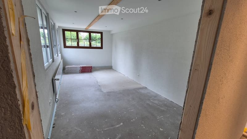 Empty room with bare walls, concrete floor, and windows. No furniture or equipment present.