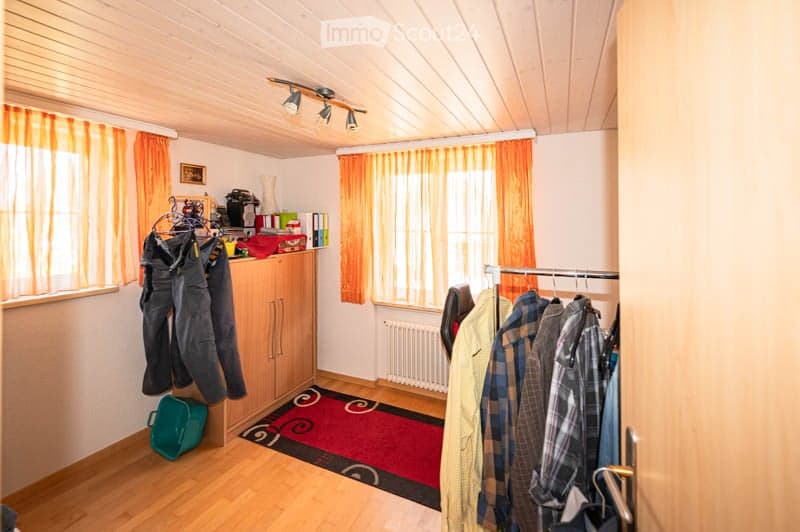 {"visible_features": [],    "type": "Room",    "description": "wooden floor, wooden cabinet, clothes hanging, radiator, carpet, window with orange curtains",    "localized_descriptions":        {        "EN": "Room: wooden floor, wooden cabinet, clot