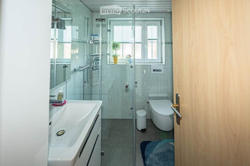 {"visible_features": [],    "type": "Room",    "description": "modern bathroom with white tiles, glass shower, white sink, toilet, window with blinds",    "localized_descriptions":        {        "EN": "modern bathroom with white tiles, glass shower