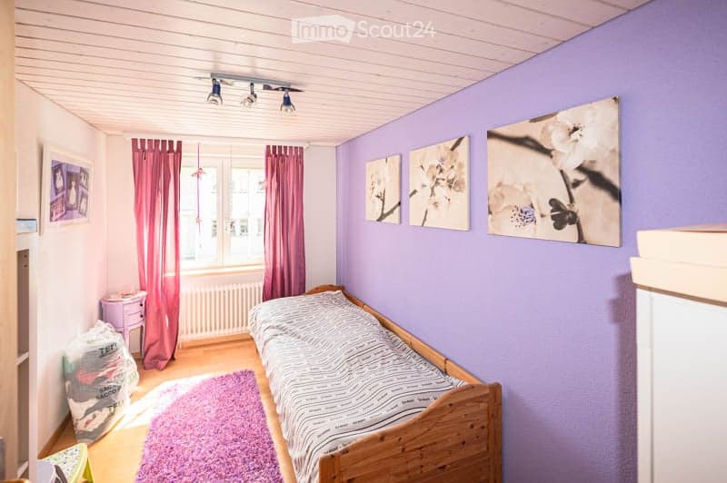 {"visible_features": [],    "type": "Room",    "description": "Bedroom with wooden bed, purple walls, pink curtains, wooden floor, three paintings, pink rug, white radiator, and a window.",    "localized_descriptions":        {        "EN": "Bedroom