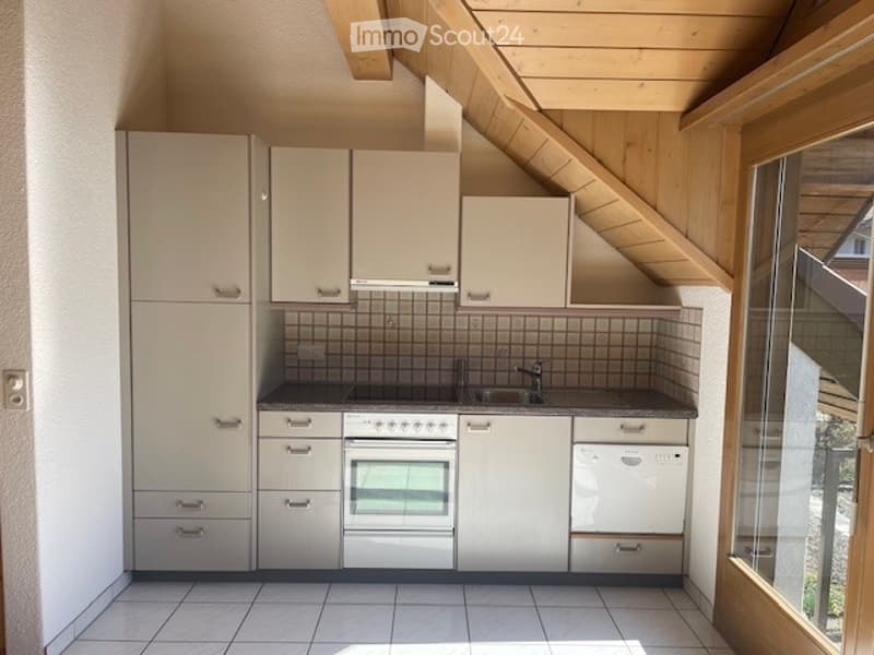 Modern kitchen with white cabinets, stainless steel appliances, and a tiled backsplash. Features an oven, dishwasher, and sink.