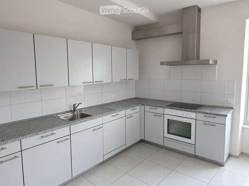 Modern kitchen with white cabinets, granite countertops, stainless steel sink, oven, and stove.
