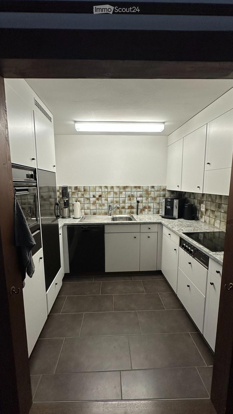 Modern kitchen with white cabinets, granite countertop, stainless steel appliances, and a tiled backsplash.