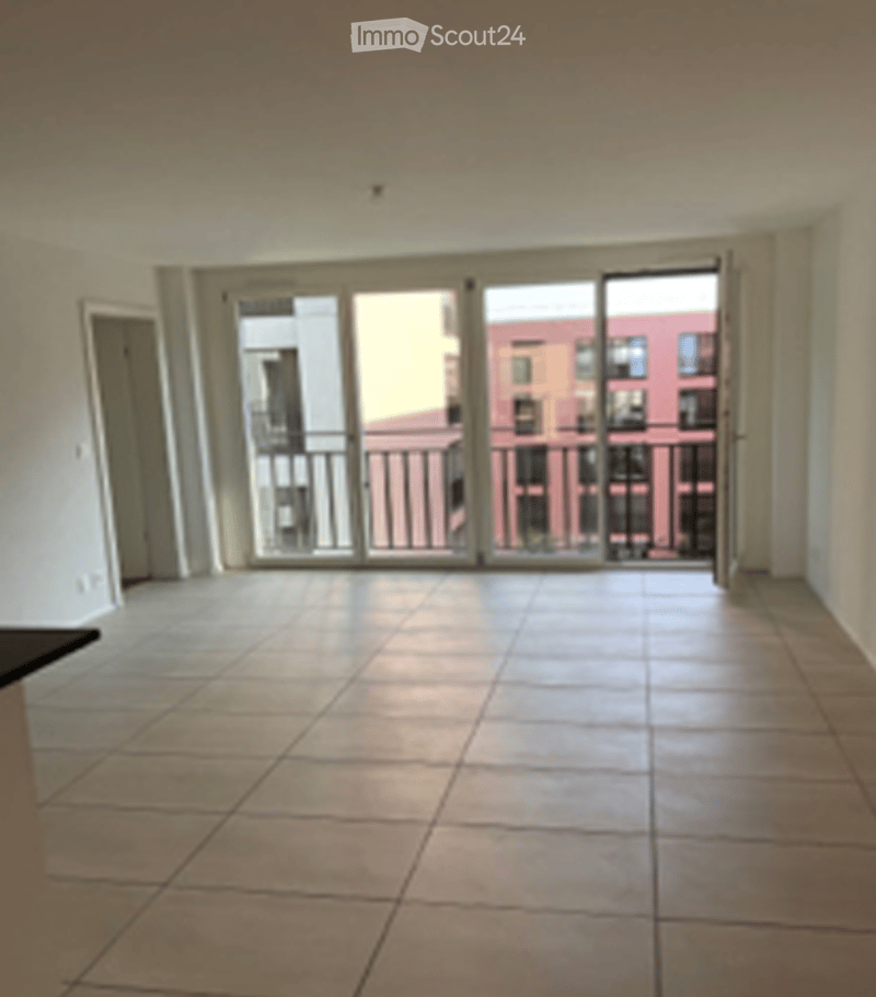 Empty room with large sliding glass doors leading to a balcony, tiled floor, and white walls.