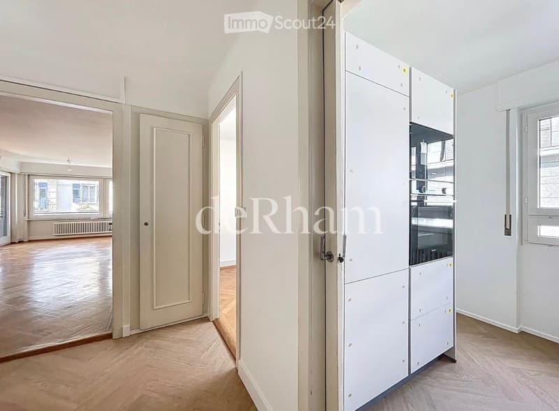 Empty room with light wooden flooring, white walls, and a white cabinet unit. The space is unfurnished with no visible furniture or equipment.