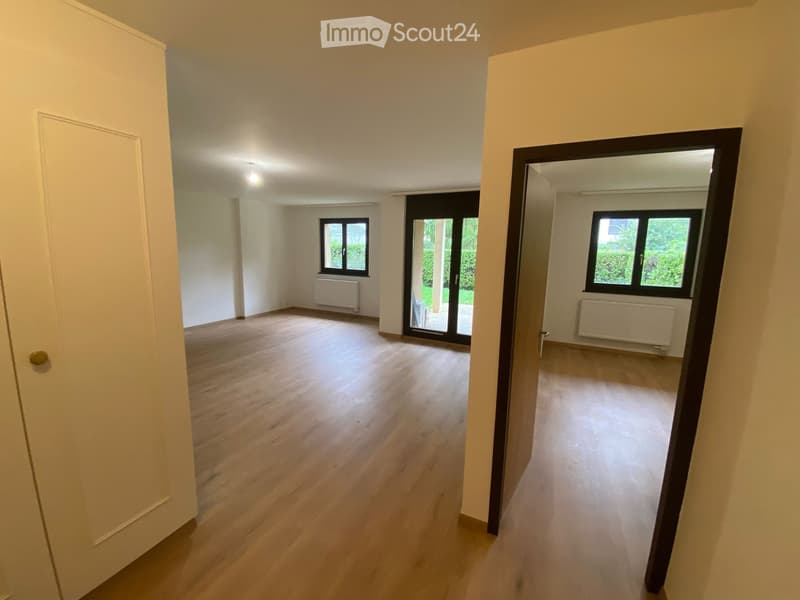 Empty room with wooden flooring, white walls, and large windows. No furniture or equipment present.