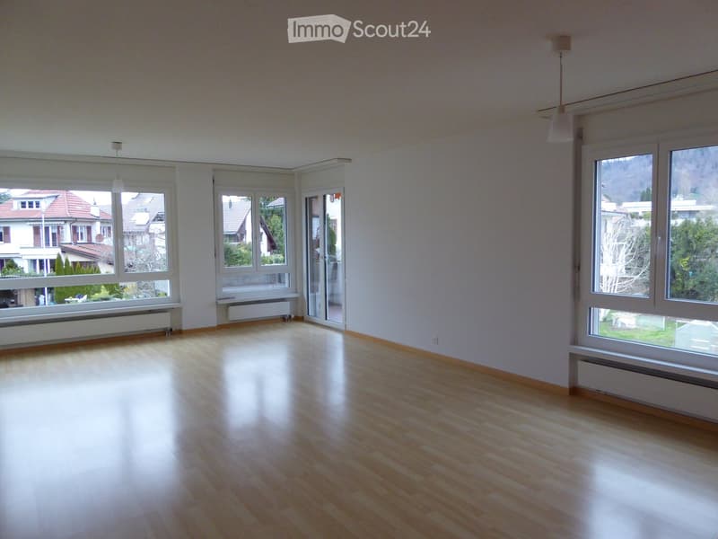 Empty room with wooden flooring, large windows, and white walls. No furniture or equipment present.