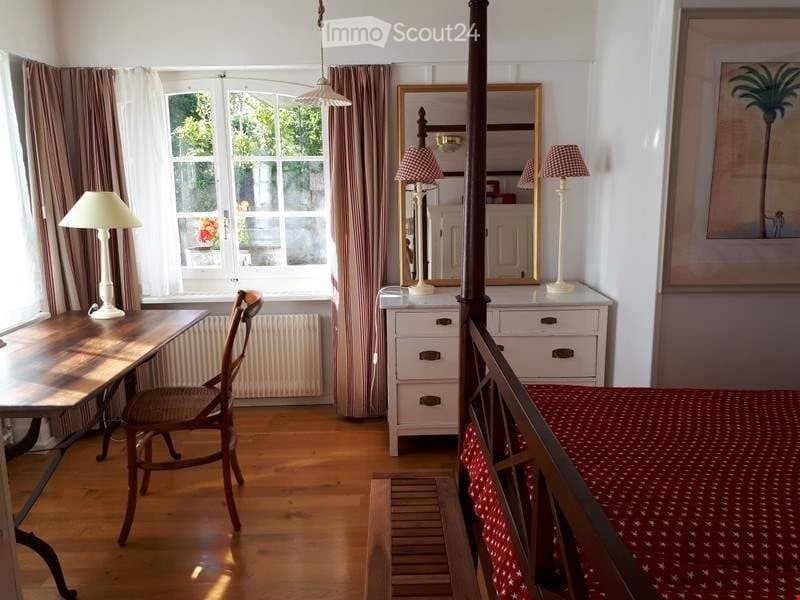 wooden floor, desk, chair, white radiator, wardrobe with mirror, lamps, painting, window with curtains