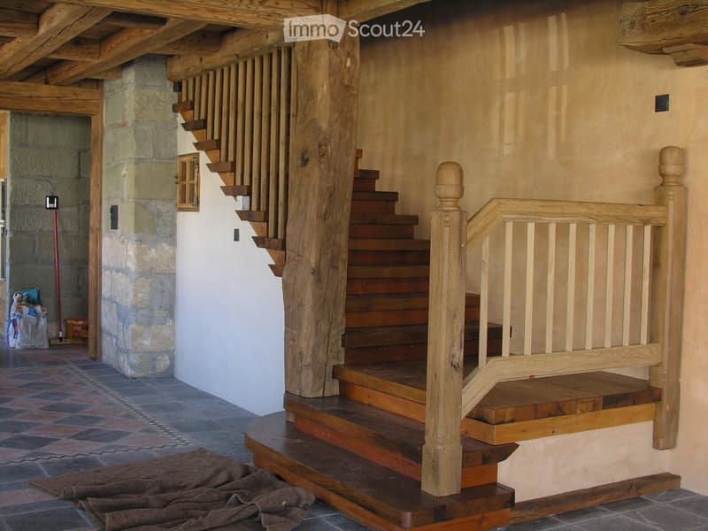 Entrance hallway with wooden stairs and landing, wooden walls, stone and tile floor