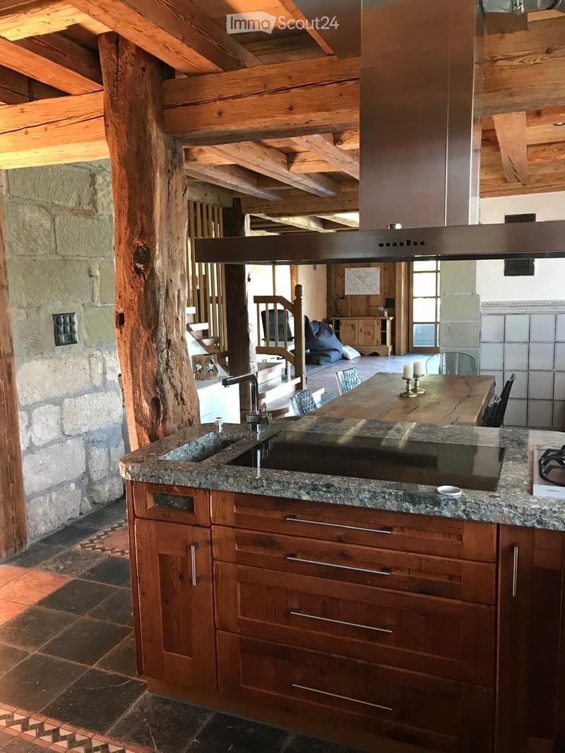 Kitchen with wooden countertop, granite slab, gas stove, marble sink, stainless steel range hood, wooden cabinets, wooden beam ceiling, tiled floor