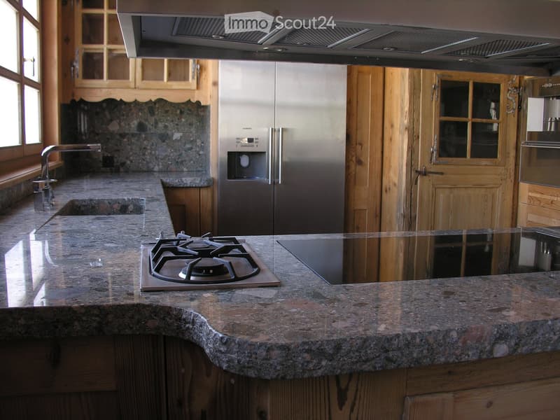modern kitchen, stainless steel fridge, granite countertop, gas stove, wooden cabinets, tiled backsplash, double sink