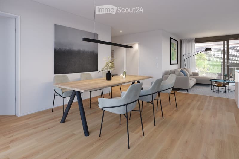 Modern open-plan living and dining area with light wooden flooring, a grey sofa, a wooden dining table with six chairs, a floor lamp, and decorative items including a vase and candles.
