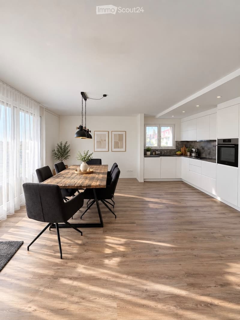 Open-plan dining and kitchen area with wooden flooring, modern white cabinets, pendant lighting, and a central dining table with chairs.