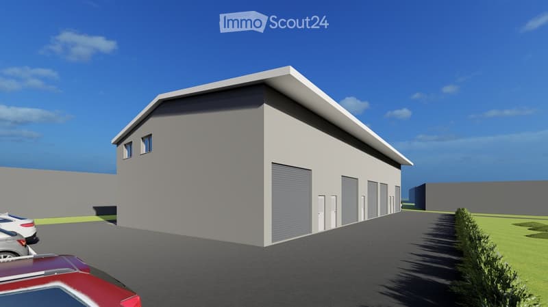 A modern, single-story building with a flat roof and multiple garage doors, surrounded by a paved area with parked cars and a small green lawn.