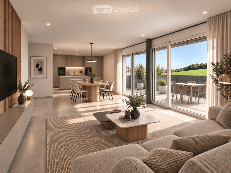Modern open-plan living and dining area with a sofa, coffee table, dining table, chairs, and a kitchen island. Large windows offer a scenic view of greenery.