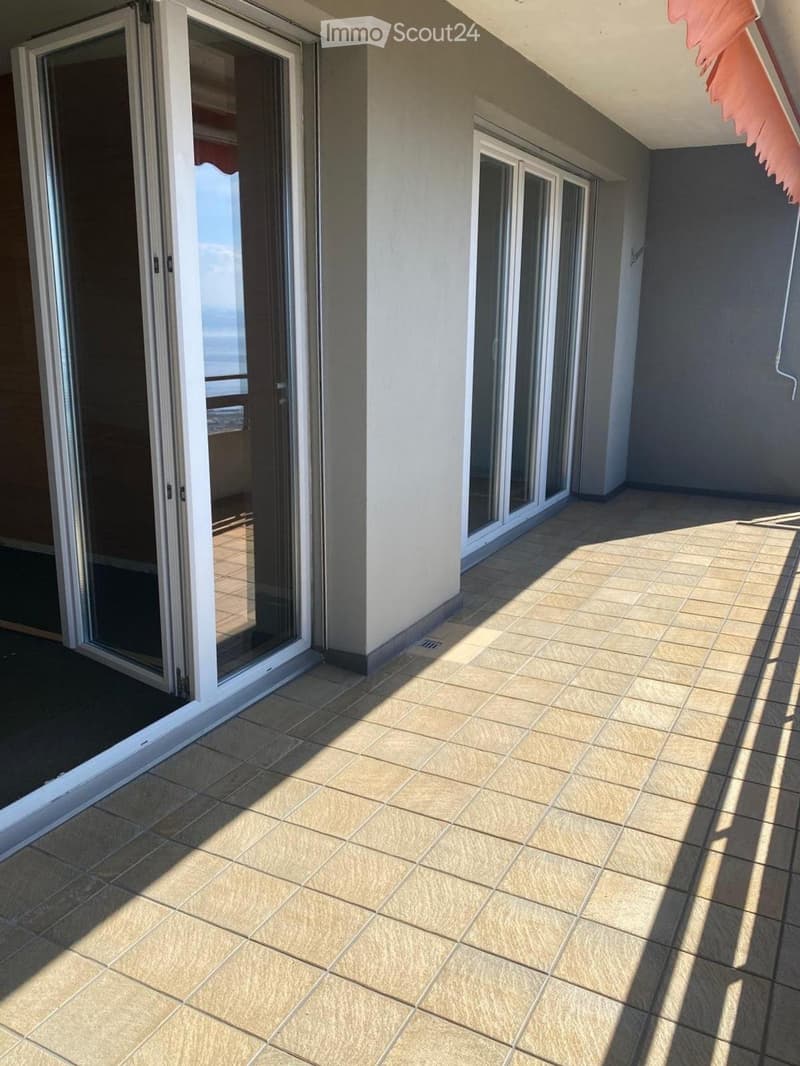Balcony with tiled floor, large sliding glass doors, and a view of the ocean.