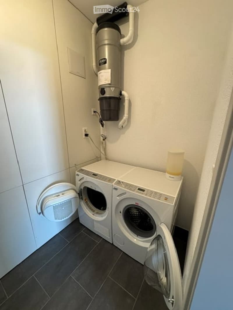 Compact laundry area with a washing machine, dryer, and air purifier mounted on the wall.