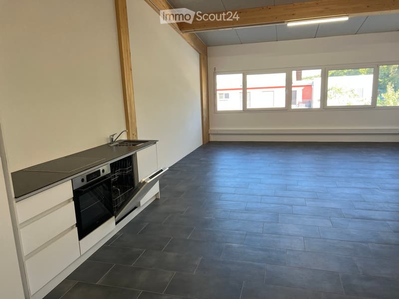 Modern kitchen with white cabinets, dark countertops, and dark tiled flooring. Features a sink, faucet, oven, and dishwasher.