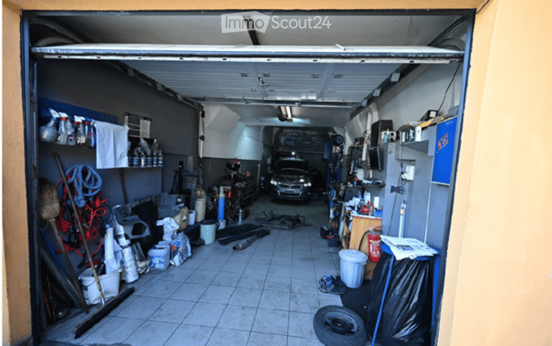 {"visible_features": ["Garage"], "type": "Garage", "objects": [], "description": "Garage with tiled floor, car parked inside, various tools and equipment, storage items, and a workbench.", "localized_descriptions": {"EN": "Garage with tiled floor, car par