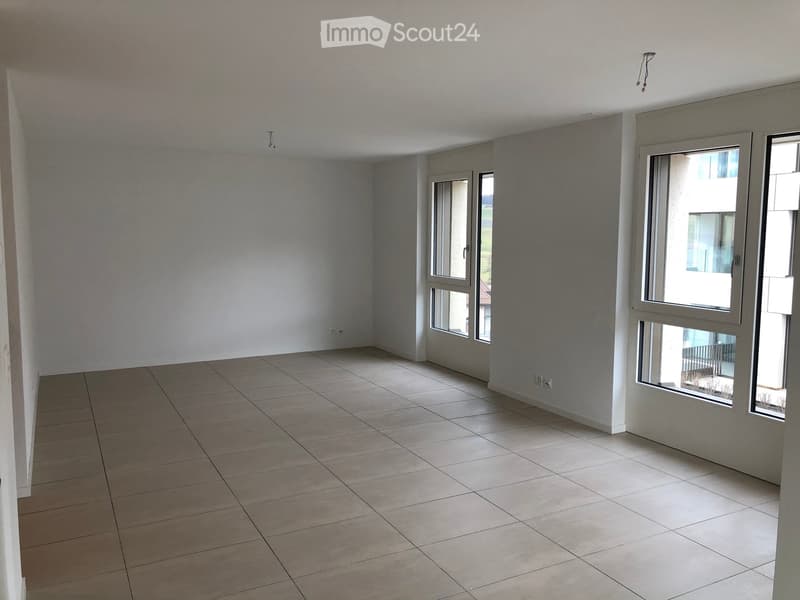 Empty room with tiled floor, white walls, and large windows allowing natural light. No furniture or equipment present.