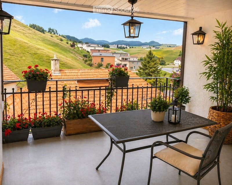 Balcony with a scenic view of a hilly landscape, featuring a metal table, a chair, potted plants, and lanterns.